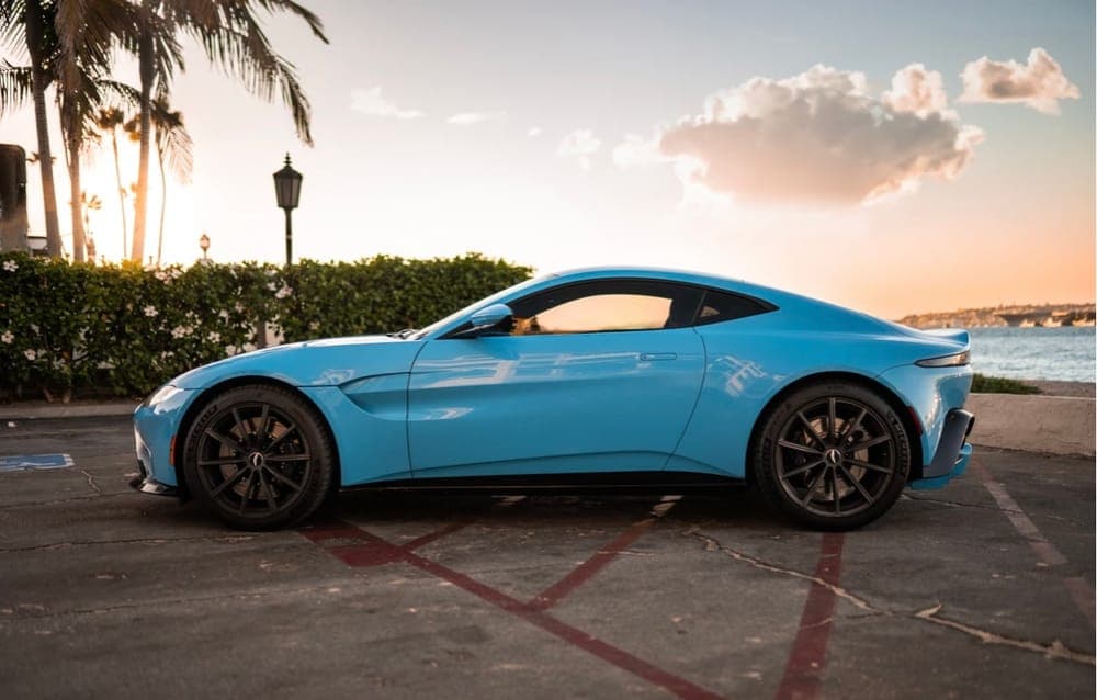 Light-blue Aston Martin Vantage at sunset