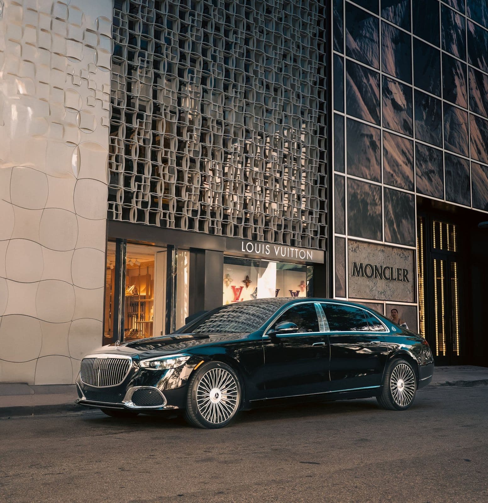Black Mercedes-Maybach parked outside a luxury boutique
